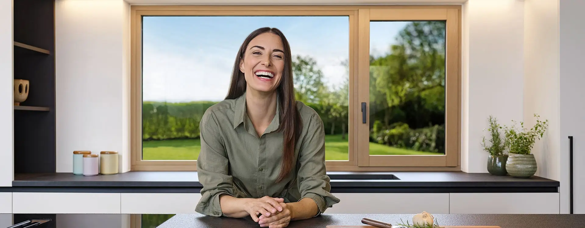 Timber-framed window with aluminium exterior and a view of green hills