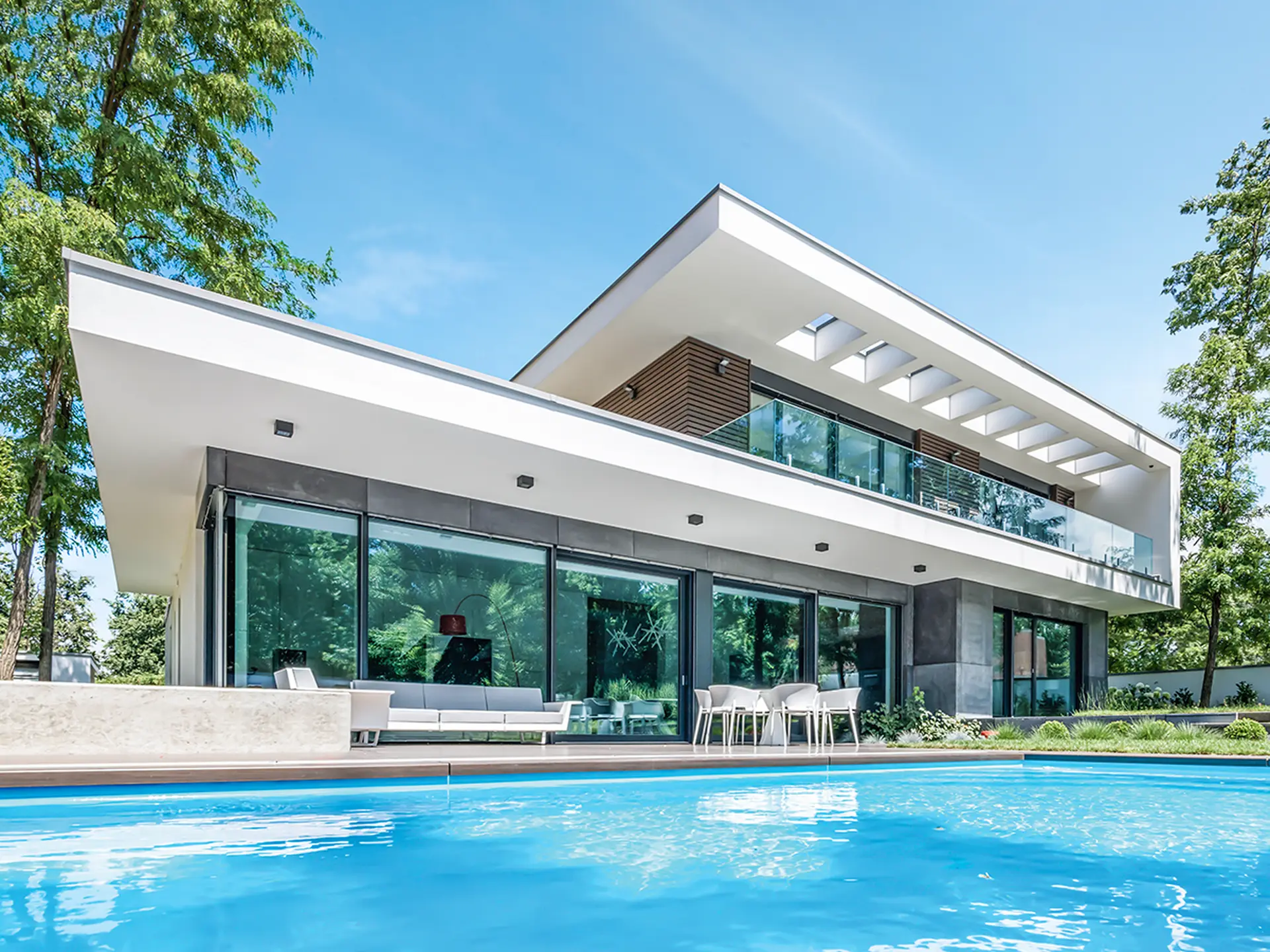 Minimalist glass house beside a swimming pool